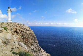 Leuchtturm Cap de Barbaria auf Formentera in karger Landschaft am Meer.